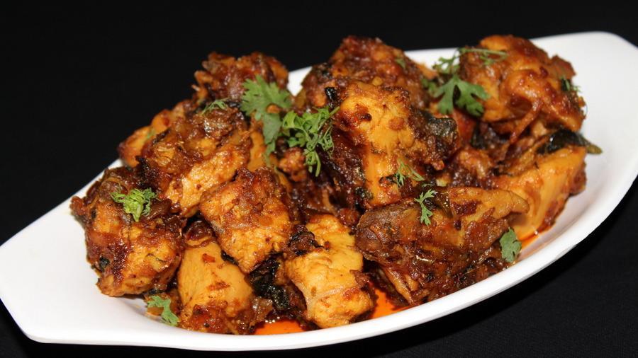 Kodi Vepudu · GLUTEN FREE - Boneless chicken cooked with curry leaves & other spices, sprayed with chili & pepper.
