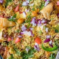 Samosa Chaat · Fried pastry topped with chickpeas, spicy mint chutney, sweet chutney, and yogurt.