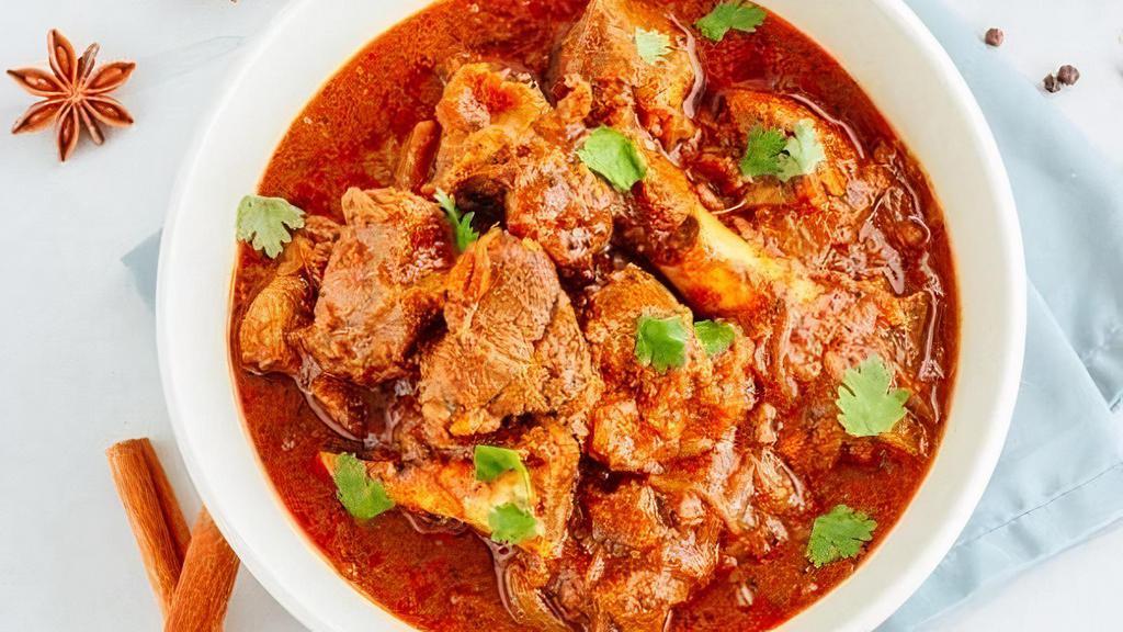 Chozhas Special Goat Curry · Goat meat on the bone cooked with garlic & ginger in a brown sauce with a compound of South Indian spices.
