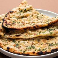 Garlic Naan · Traditional Indian bread with butter baked in clay oven topped with chopped garlic.