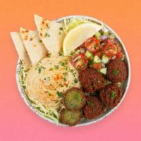 Falafel Hummus Bowl · Crispy falafel over hummus, diced cucumber and tomato salad, shredded green cabbage and a dr...