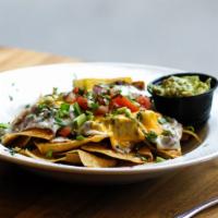 Nachos · Served with chili con carne refried black beans and charred chipotle salsa.