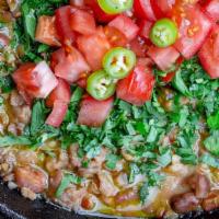 Egyptian Beans فول حجازي · Mashed fava beans topping cilantro, tomato, onion, garlic, tahini sauce, cumin, sizzling but...