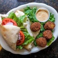 Jerusalem Falafel · Deep fried vegetables falafel topped with a salad mix and tahini sauce in a homemade pita br...