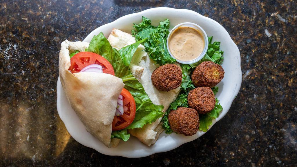 Jerusalem Falafel · Deep fried vegetables falafel topped with a salad mix and tahini sauce in a homemade pita bread pocket.