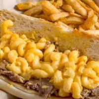 Mac N Cheesesteak · Shaved ribeye steak with our homemade mac n cheese layered on it. Served on a toasted roll.