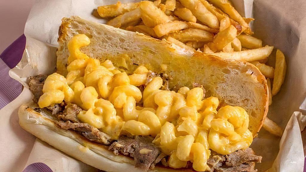 Mac N Cheesesteak · Shaved ribeye steak with our homemade mac n cheese layered on it. Served on a toasted roll.
