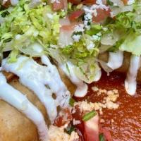 Flautas De Pollo · Two crispy corn tortillas, each cut in half and filled with chicken, potato, and queso fresc...