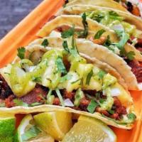 Tacos Al Pastor · Marinated pork topped with pineapple, cilantro, onion.