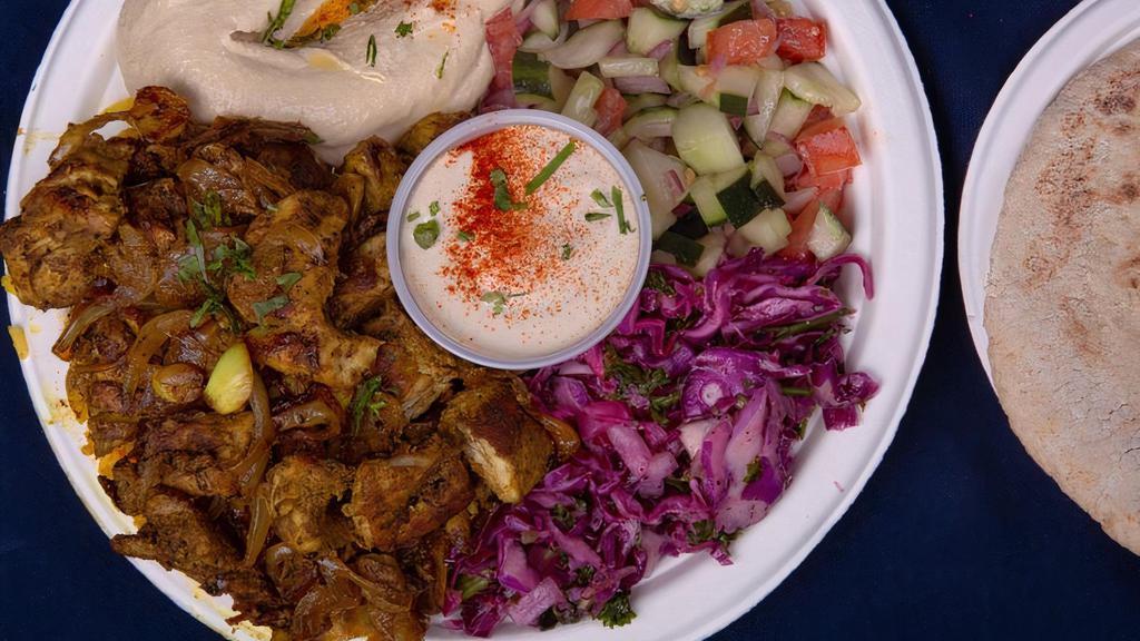 Chicken Shawarma Plate · w/ Israeli salad, red cabbage salad, rice, hummus, tahini and pita