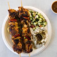 Grilled Chicken Skewers · Two grilled mediterranean chicken skewers laid over Za’atar pita served  w/ za’atar labneh, ...