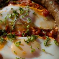 Shakshookah W/ Merguez Sausage · Two eggs poached, Madboukha, Hummus, Salad, Pita