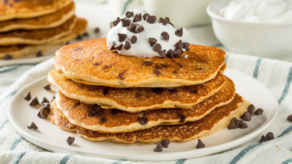 Chocolate Chip Pancakes · Short stack of fluffy chocolate chip pancakes topped with maple syrup.