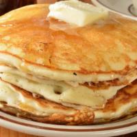 Buttermilk Pancakes With Meat · Shortstack of fluffy pancakes topped with maple syrup and a choice of meat on the side.