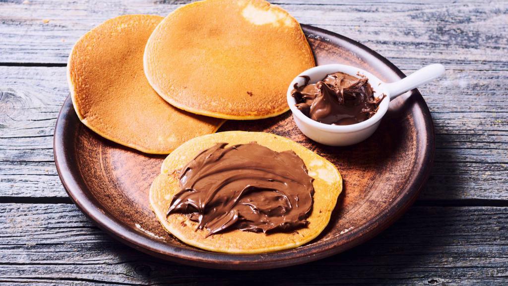 Nutella Pancakes · Shortstack of fluffy nutella pancakes topped with maple syrup.