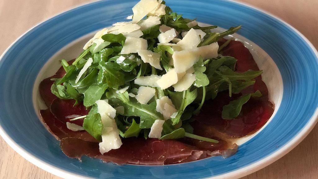 Carpaccio Di Bresaola · Carpaccio di bresaola (cured beef) with arugula and shaved Parmigiano topped with lemon dressing.