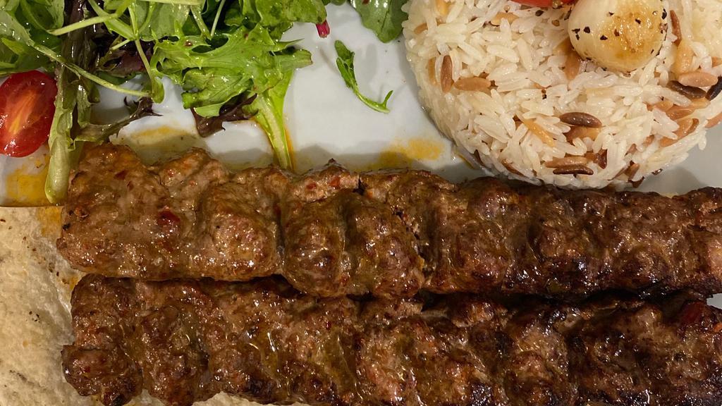 Adana Kebab · 2 skewers of finely chopped lamb mixed with red bell pepper & fresh herbs served with rice and mix green salad