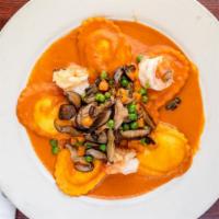 Lobster Ravioli · Ravioli with shiitake mushrooms, peas, and carrots in a  pink sauce