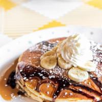 Peanut Butter-Banana Pancakes · Buttermilk pancakes with nutella cream filling, topped with warm peanut butter sauce, dark c...