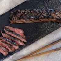 Grilled Steak · Flank steak with garlic, ginger, sesame oil, and lime, cooked medium rare
