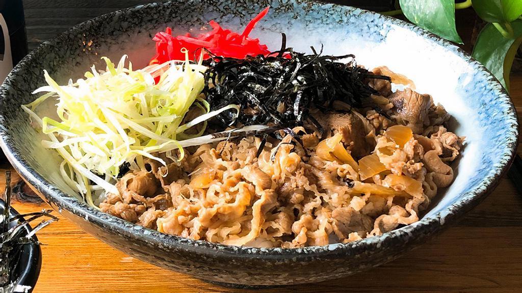 Gyu Don · Marinated and thinly sliced beef brisket cooked with onions served over rice, topped with pickled ginger, scallion, sesame seeds, and shredded nori.