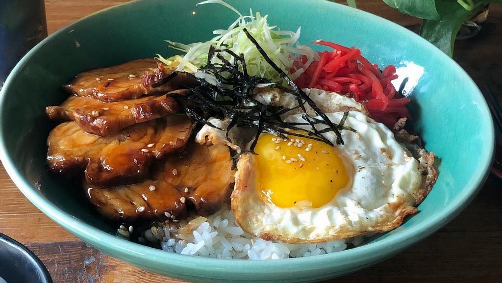 Chashu Don · Braised pork belly served over rice with fried egg, pickled ginger, scallions, sesame seeds, and shredded nori.