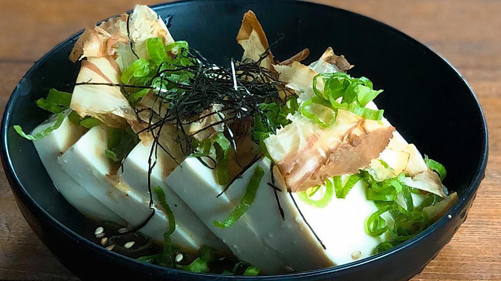 Hiyayakko · Tofu dressed with ginger, cold soba soup, and soy sauce, topped with bonito flakes, green scallions, and hari nori.