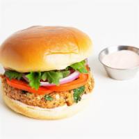 Salmon Burger · Salmon burger with tomato, red onion, and aioli on a brioche bun.