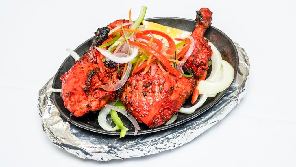 Tandoori Chicken · Chicken marinated in yogurt, mild spices and roasted over charcoal in the tandoor.