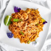 Pad Thai Noodles · Flat noodles in Thai sauce garnished with peanuts and a wedge of lime.