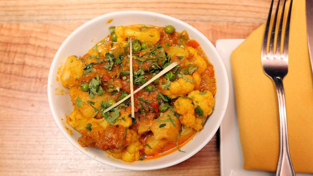 Aloo Gobi Mutter · Potatoes and cauliflower cooked with green peas and Indian spices.