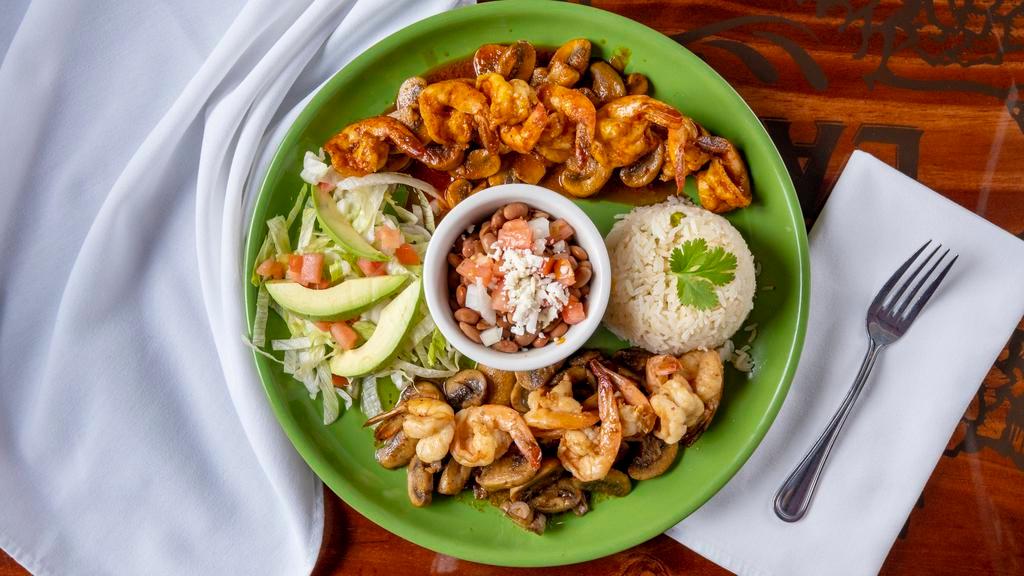 Camarones Cancun · Tender Shrimp and mushrooms prepared 2 ways, half sauteed in butter garlic with spices and the other half marinated in a  red spicy sauce. Served with white rice and garnished with lettuce, tomatoes, lime and avocado.