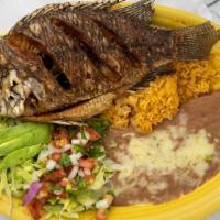 Mojarra Frita · Tilapia fried. Topped with sauteed onions and mushrooms. Served with white rice and refried ...