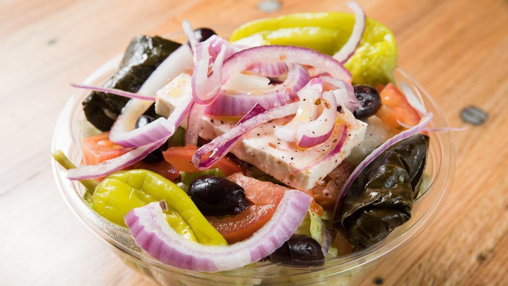 Greek Salad · Mixed greens, tomatoes, cucumbers, red peppers, grape leaves, feta cheese, olives, red onions.