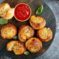 Garlic Knots · Warm fresh baked dough infused with garlic, parsley and parmesan cheese.