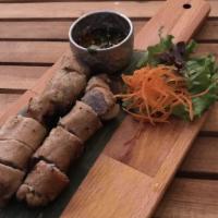 Moo Yang Hor Khao Neual · (Pork Tenderloin Roll) pork rollatini marinated with 3 musketeers' (cilantro, garlic, black ...