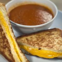 Grilled Cheese With Tomato Soup · House made tomato soup served with a combination of American and cheddar cheese grilled betw...
