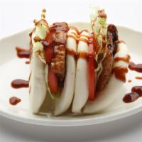 Pork Bao · Steam buns filled with pork belly, tomatoes and lettuce. Served as 2 pieces.