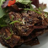 Kalbi · Korean-style grilled short ribs, served with rice and salad.