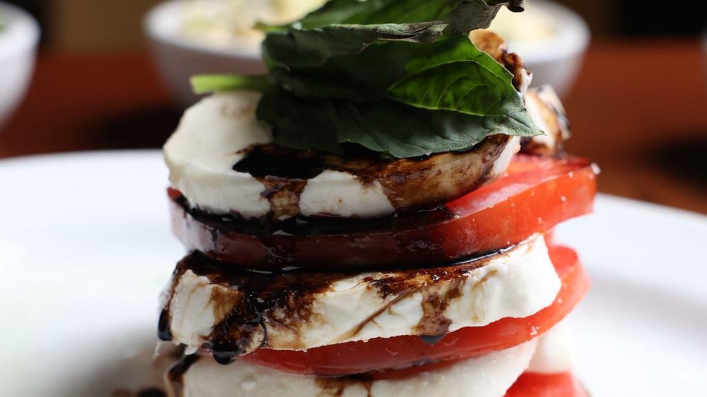 Caprese Salad · Fresh mozzarella, beefsteak tomatoes, balsamic reduction, garlic crema and fresh basil. Gluten free.