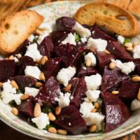 Roasted Beets · Roasted with fresh herbs and garlic, topped with pine nuts and goat cheese.