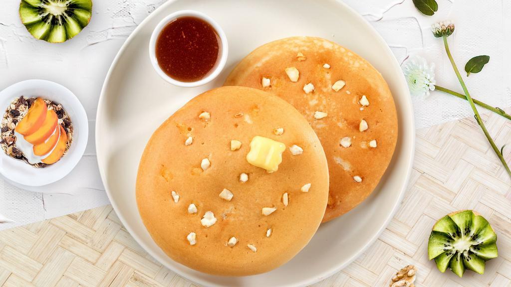 Snowy Chocolate Pancakes · Fluffy white chocolate chip pancakes cooked with care and love served with butter and maple syrup. Three pancakes.