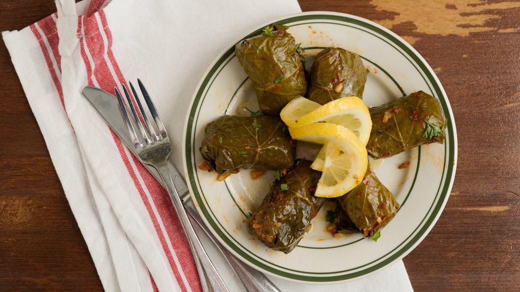 Dolmadakia · Homemade grape leaves served warm and stuffed with rice, fresh dill, lemon and Greek olive oil.