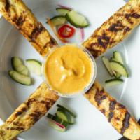 Chicken Satay · With peanut sauce and cucumber ajard.