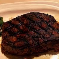 Steak · Grilled sliced steak with caramelized onions, roasted red peppers, mixed greens, and aioli o...