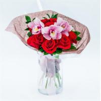 Orchid & Rose · The Orchid & Rose arrangement is presented without a vase as a compact dome of red roses, pi...