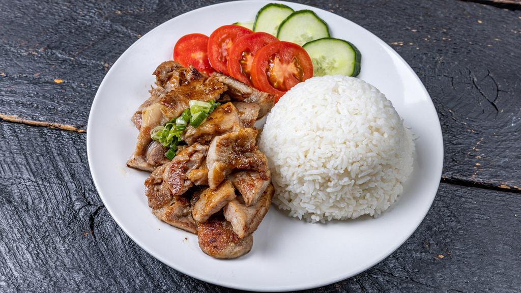 Pork Chop On Rice · Grilled pork chop served on rice, cucumber, and tomatoes.