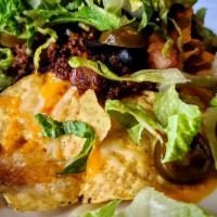 Nachos With Chili · Tortilla chips covered with chili, jalapeños, shredded lettuce, tomato, black olives, and to...