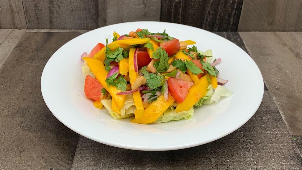 Thai Mango Salad · Thai mango, cashew nut, scallions , cilantro , tomato, red onions ,lettuce, chili lime dressing.