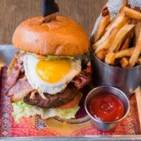 Hungry Burger · Served with grilled onions, guacamole, bacon, fried egg, lettuce, tomato, and fries.